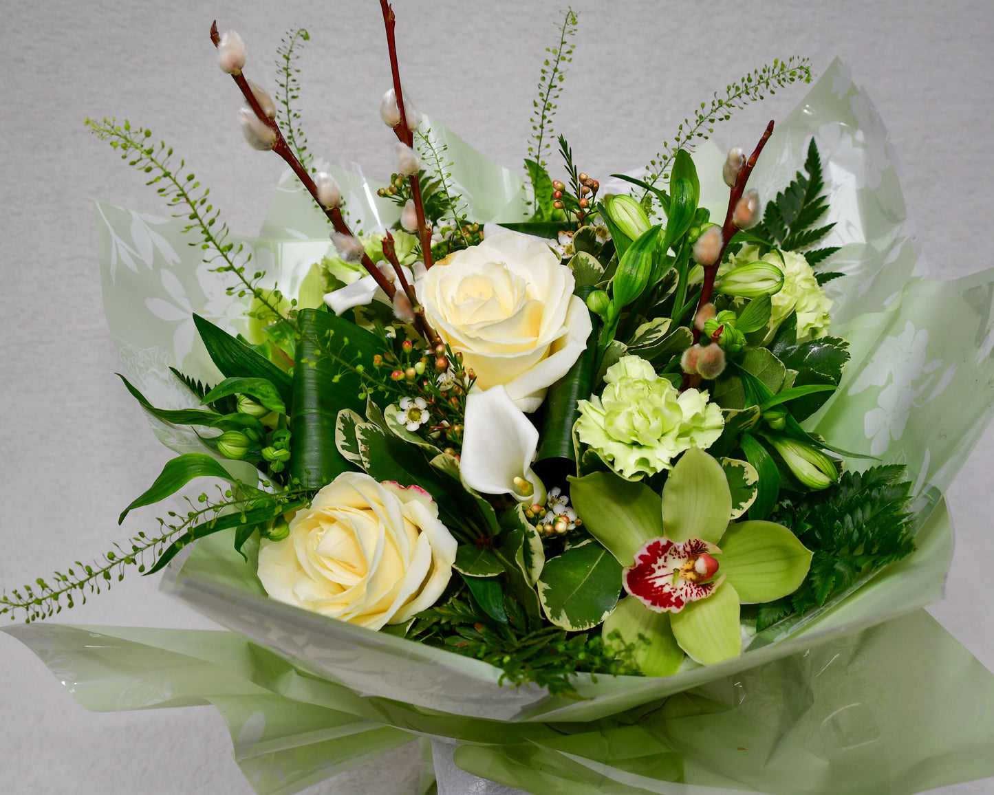 Hand-tied, gift wrapped bouquet including a selection of green and white flowers with complimentary foliage