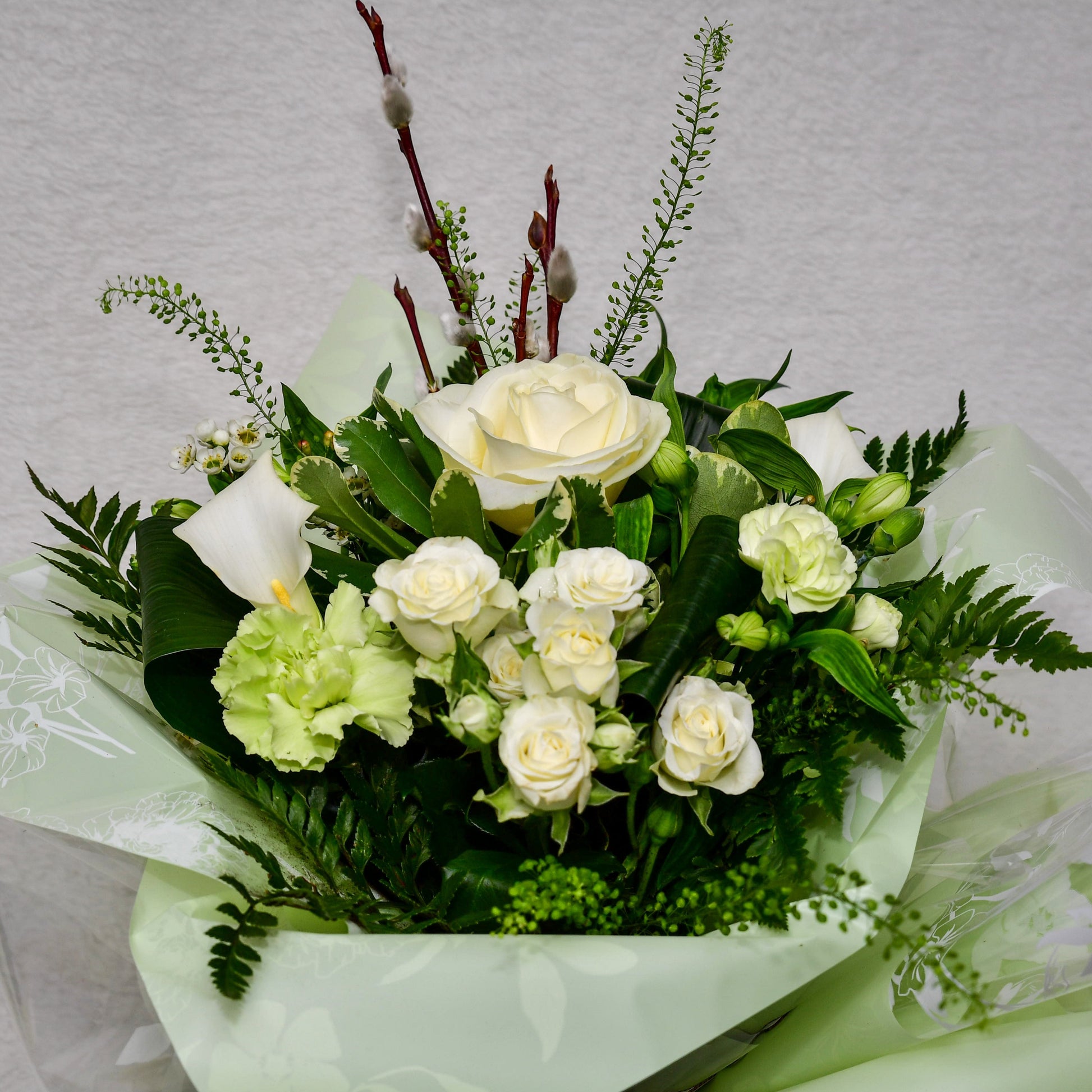 Hand-tied, gift wrapped bouquet including a selection of green and white flowers with complimentary foliage
